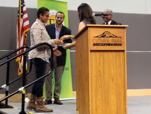Diem Ly hands a Comcast Technology Scholarship recipient their award. 