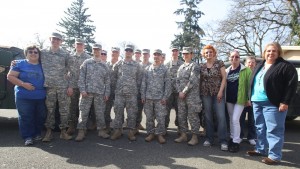 Soldiers pose with workers from the Tillicum food bank.
