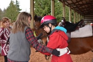 In Equine Assisted Therapy, both a licensed therapist and horse professional work with clients. Above, left to right: Volunteer coordinator Toni Hughes and education specialist Julie Cislo partner with Ellen Hampton and quarter horse Whisper. Photo courtesy of Changing Rein/Doug Loates.