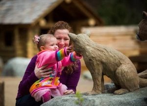 A toddler gets acquainted with a replica cougar cub in the Kids’ Trek play area at Northwest Trek. Photo courtesy: Northwest Trek Wildlife Park. 