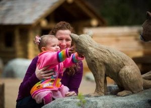 A toddler gets acquainted with a replica cougar cub in the Kids’ Trek play area at Northwest Trek. Photo courtesy: Northwest Trek Wildlife Park.