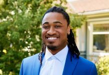 Redfin agent Kareem Dixon smiles for a portrait photo in a blue suit jacket and white button up collared shirt.