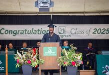 Humanitarian and influencer Kwabi Amoah-Forson stands at a podium with staff from Evergreen State College sitting behind him. a Banner says "Congratulations Class of 2025 - Evergreen" on the wall behind them